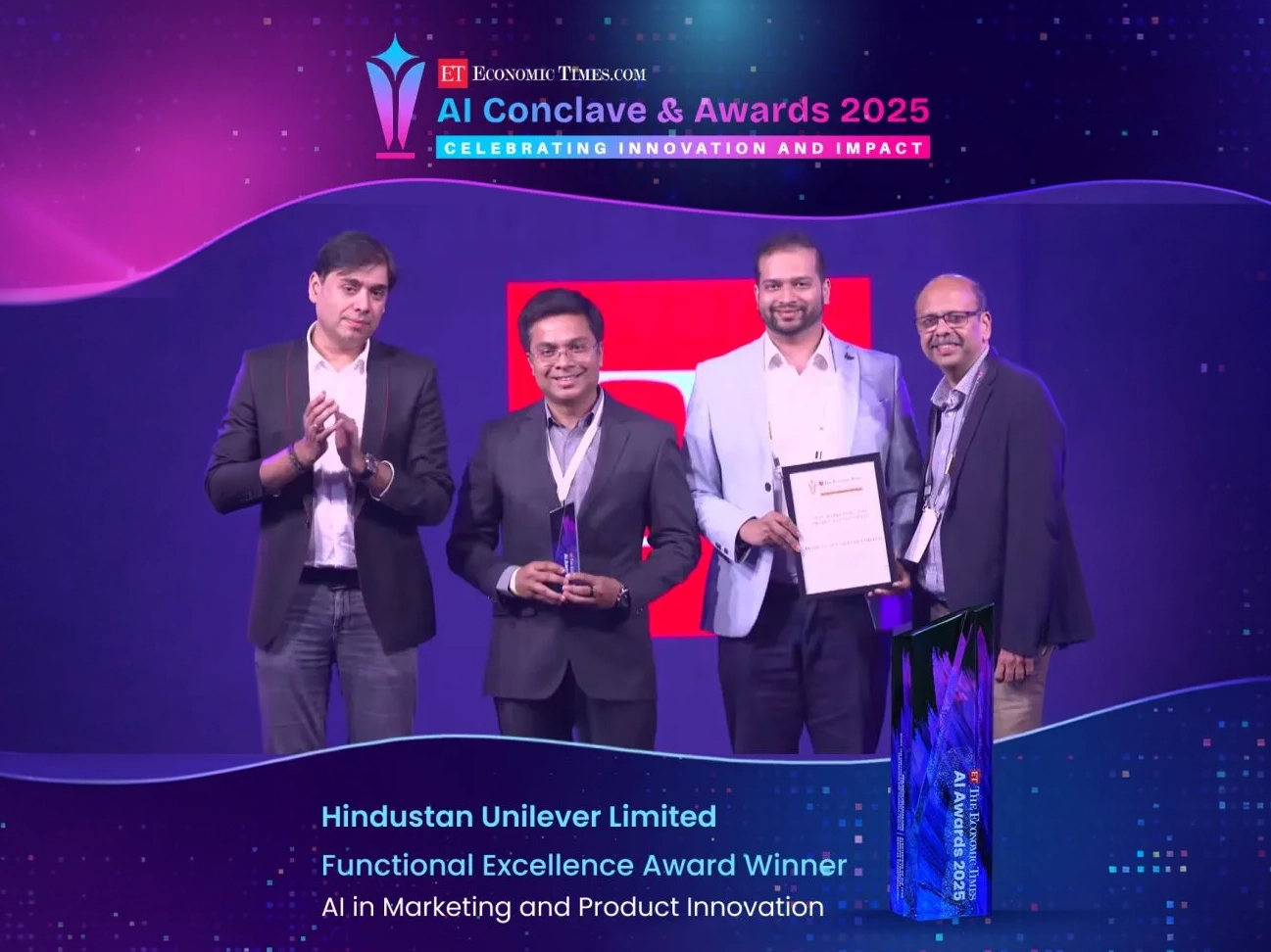People on stage receiving the E T A I Award.